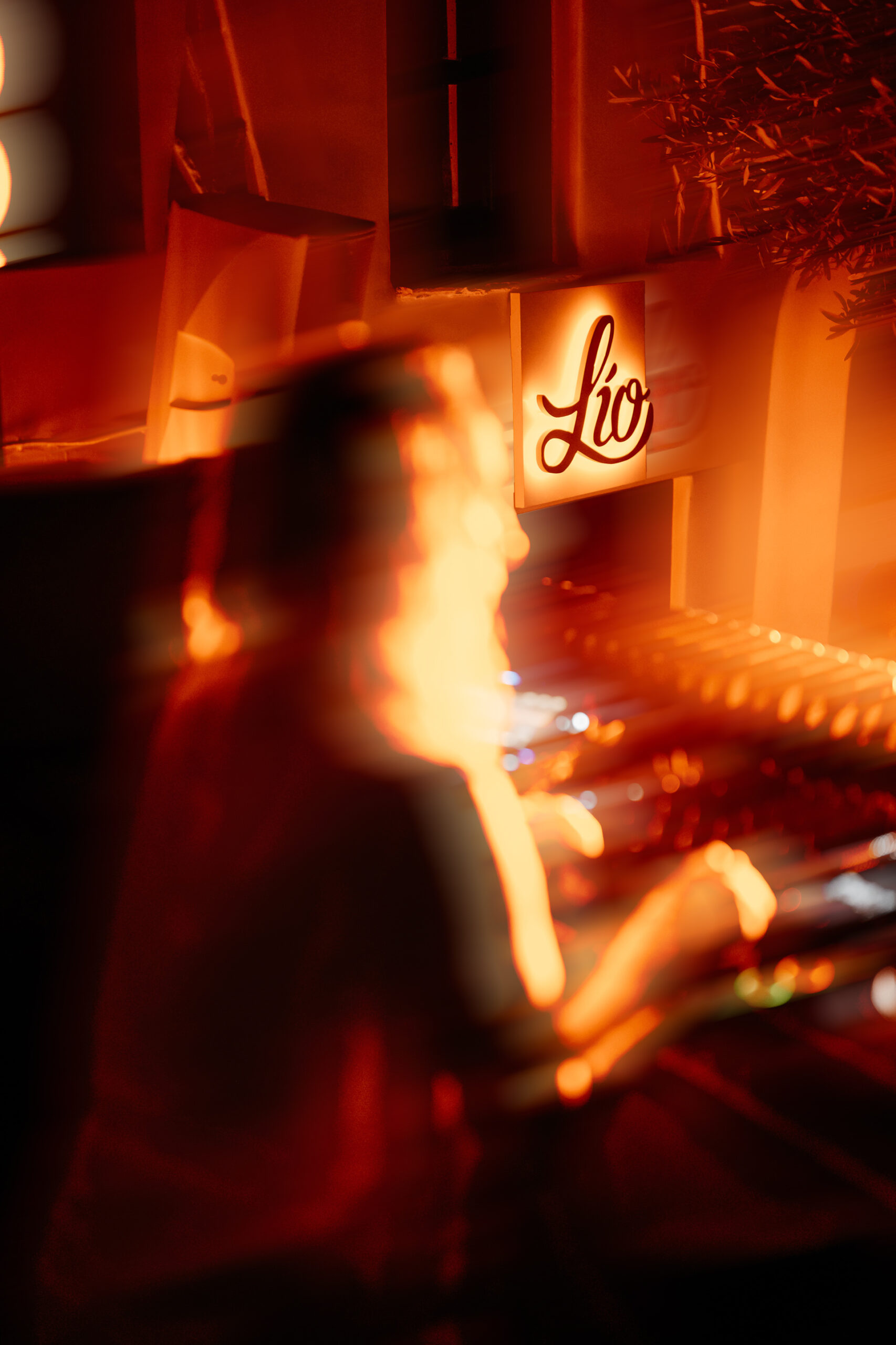 L&iacute;o Mykonos: One Last Spectacularrr Night. A pianist performing beside an illuminated L&iacute;o sign.