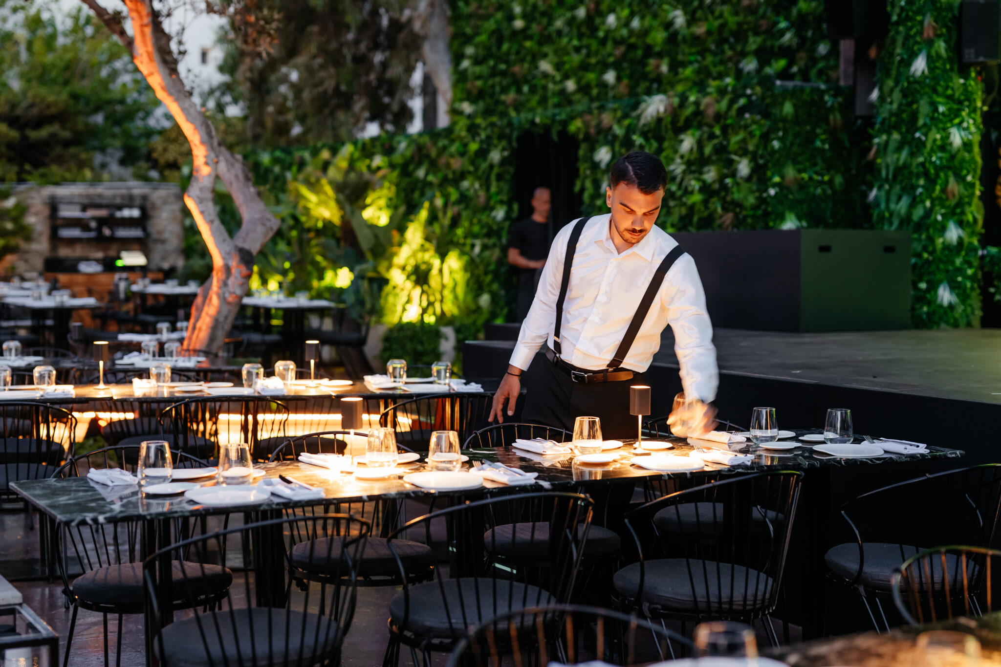 L&iacute;o Mykonos: One Last Spectacularrr Night. A member of staff preparing the open-air dining area at L&iacute;o Mykonos.