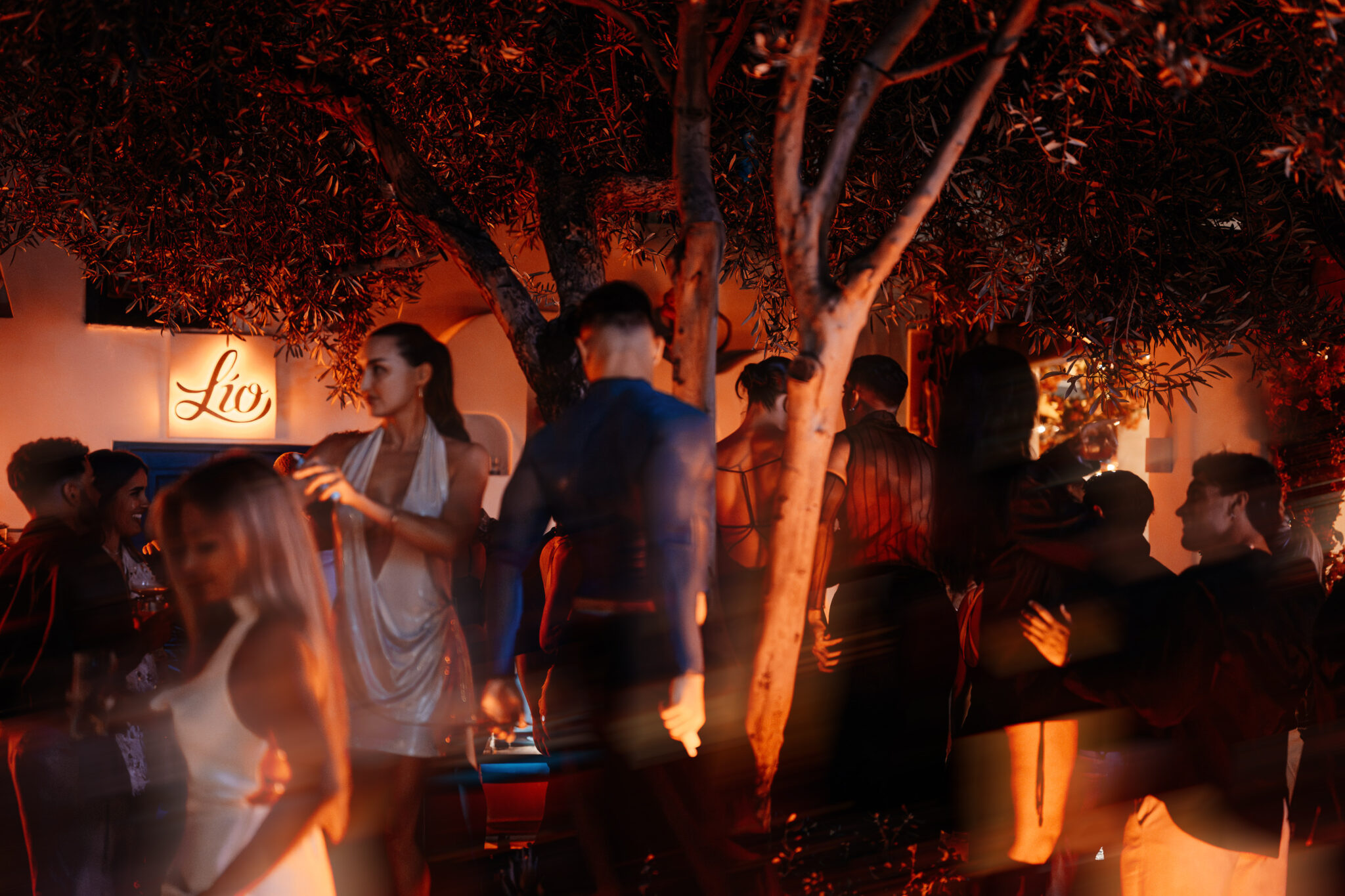 L&iacute;o Mykonos: One Last Spectacularrr Night. Guests socializing in the garden at L&iacute;o Mykonos after dark.