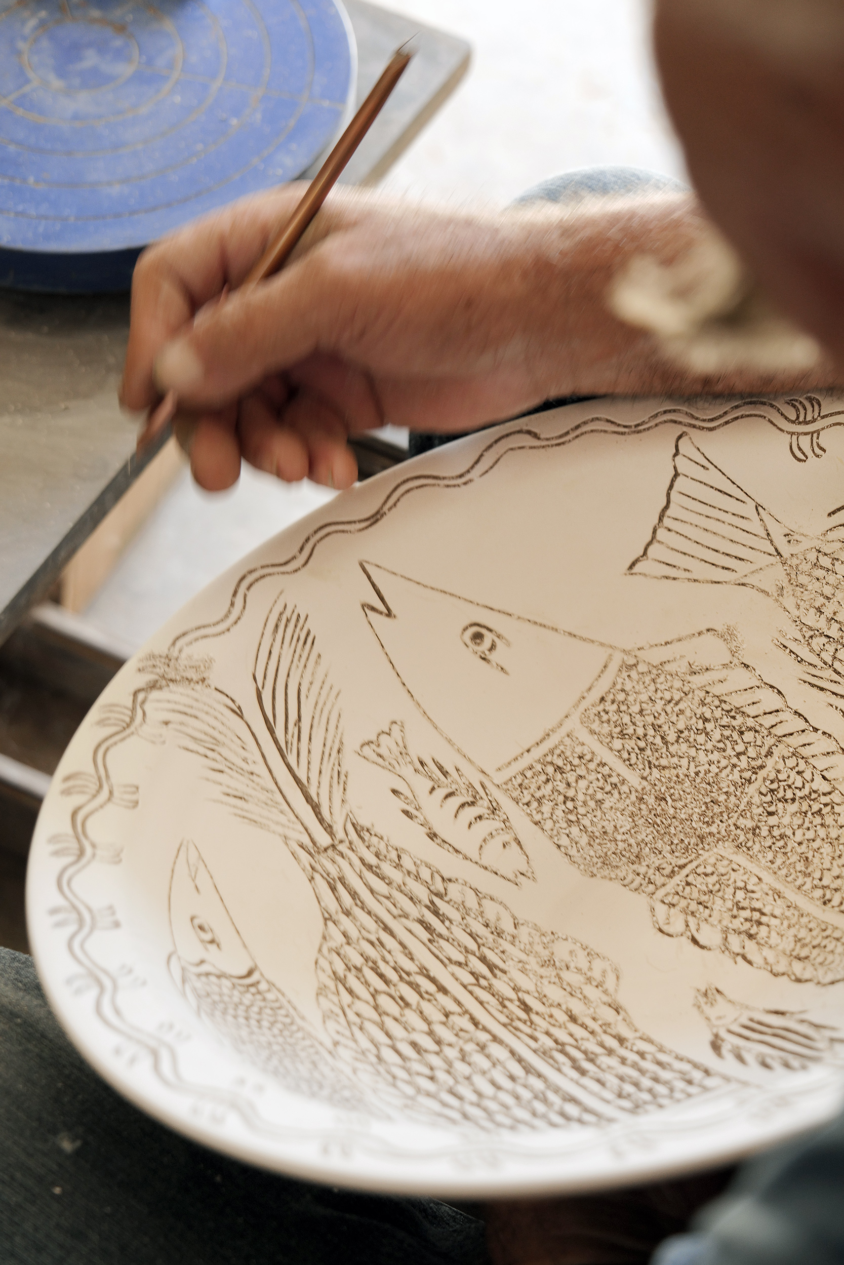 Inside the Pottery Workshops of Sifnos: decorating a plate at the Lebesis workshop