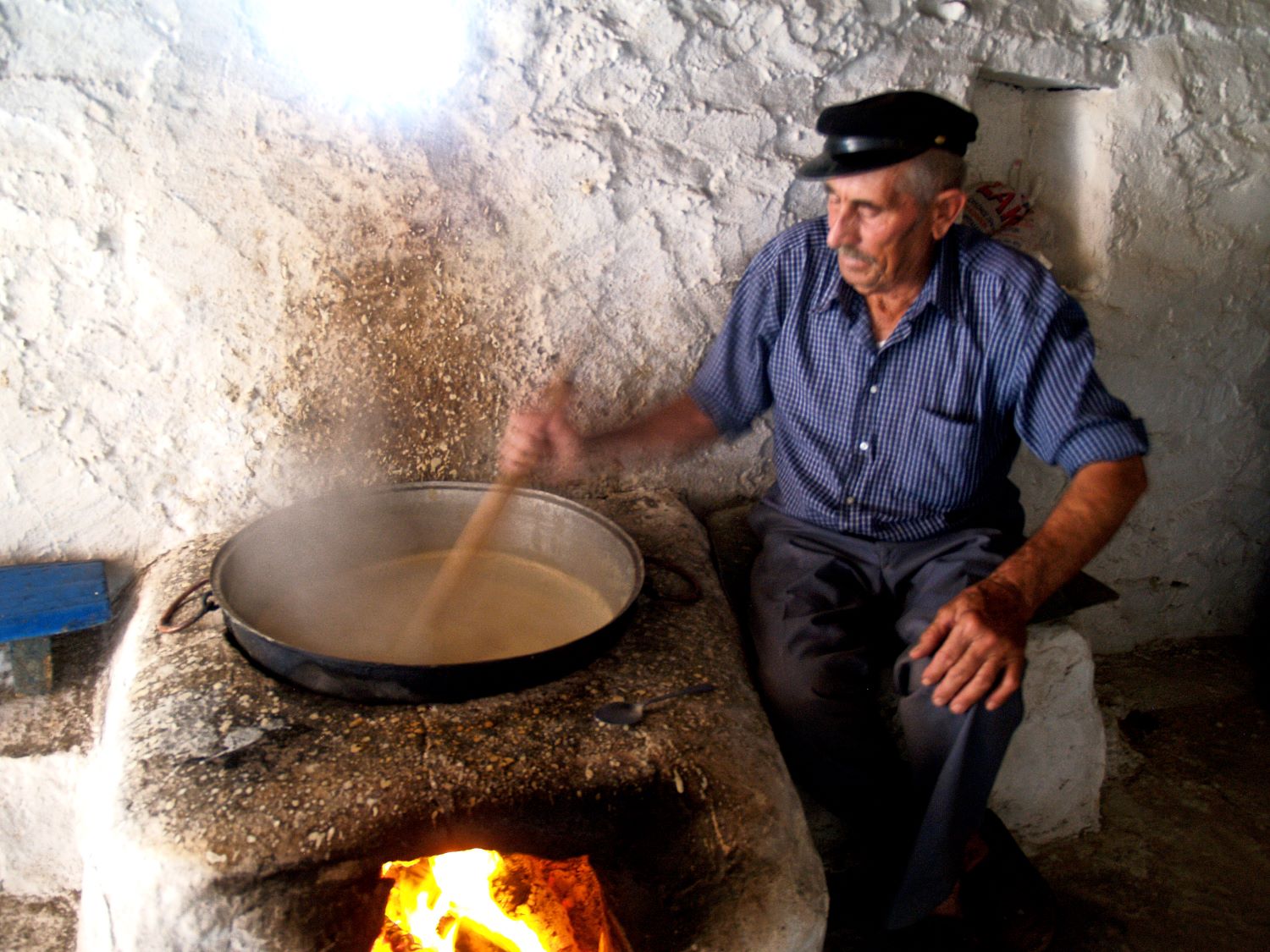 Cheeses of the South Aegean: A cheesemaker stirring sitaka over a fire on Kasos