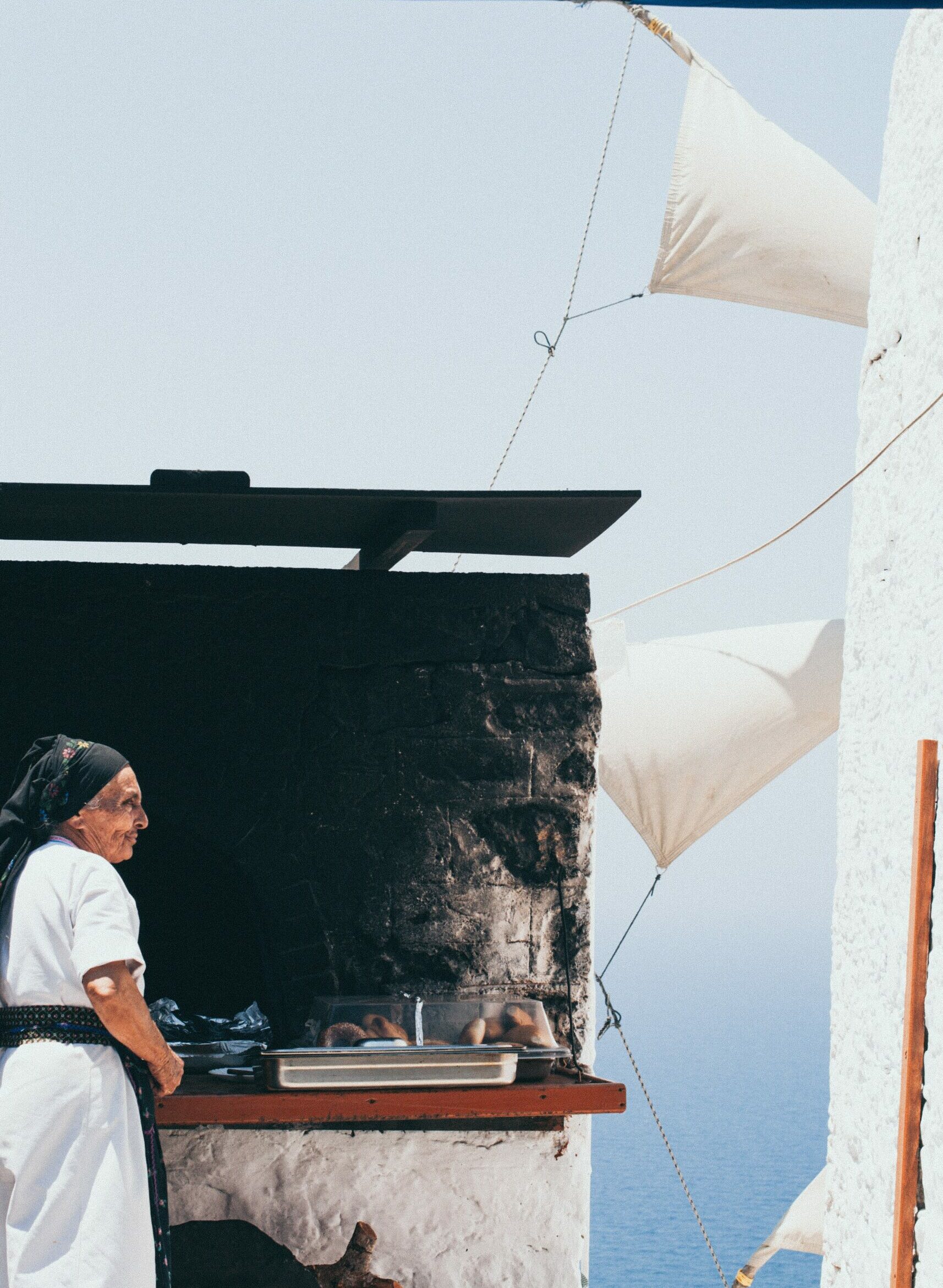 Cheeses of the South Aegean: A woman beside a traditional stone oven in Olympos, Karpathos