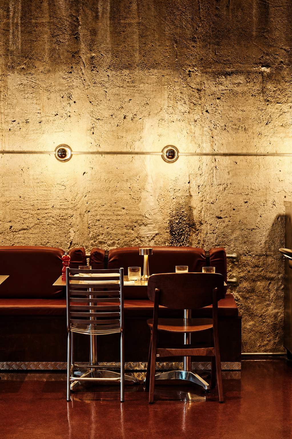 Koukaki&rsquo;s Best Places to Eat: Voulkanizater, tables and chairs against a textured concrete wall