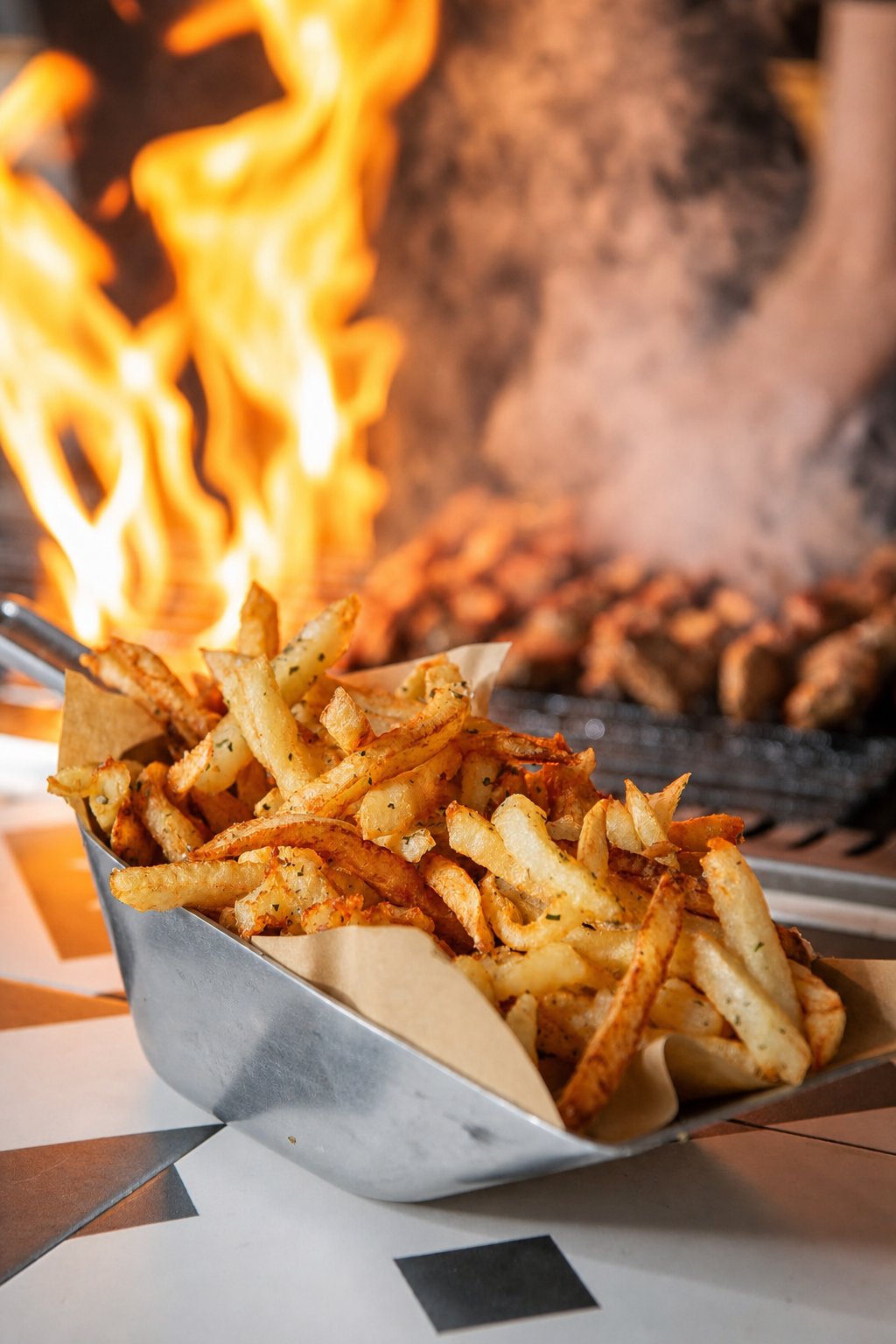 Koukaki&rsquo;s Best Places to Eat: Kalamaki Bar, fries beside skewers cooking over flames
